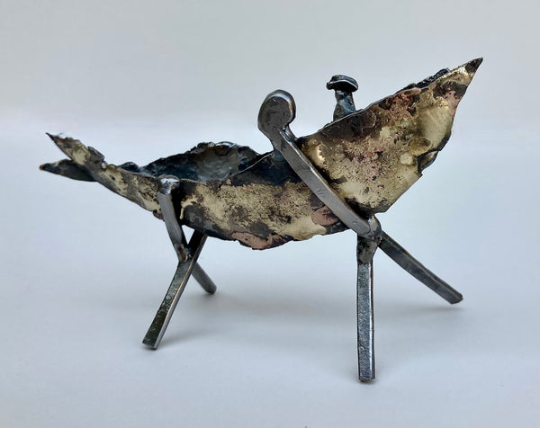 Abstract metal sculpture of a boat on two x-shaped stands.